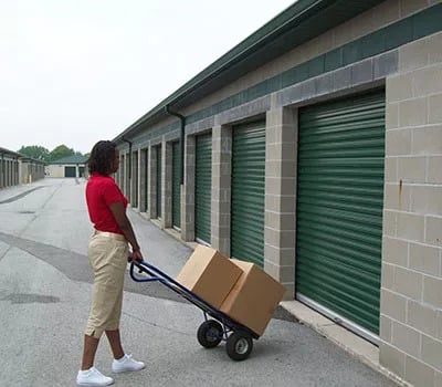 A woman loading boxes into a storage unit